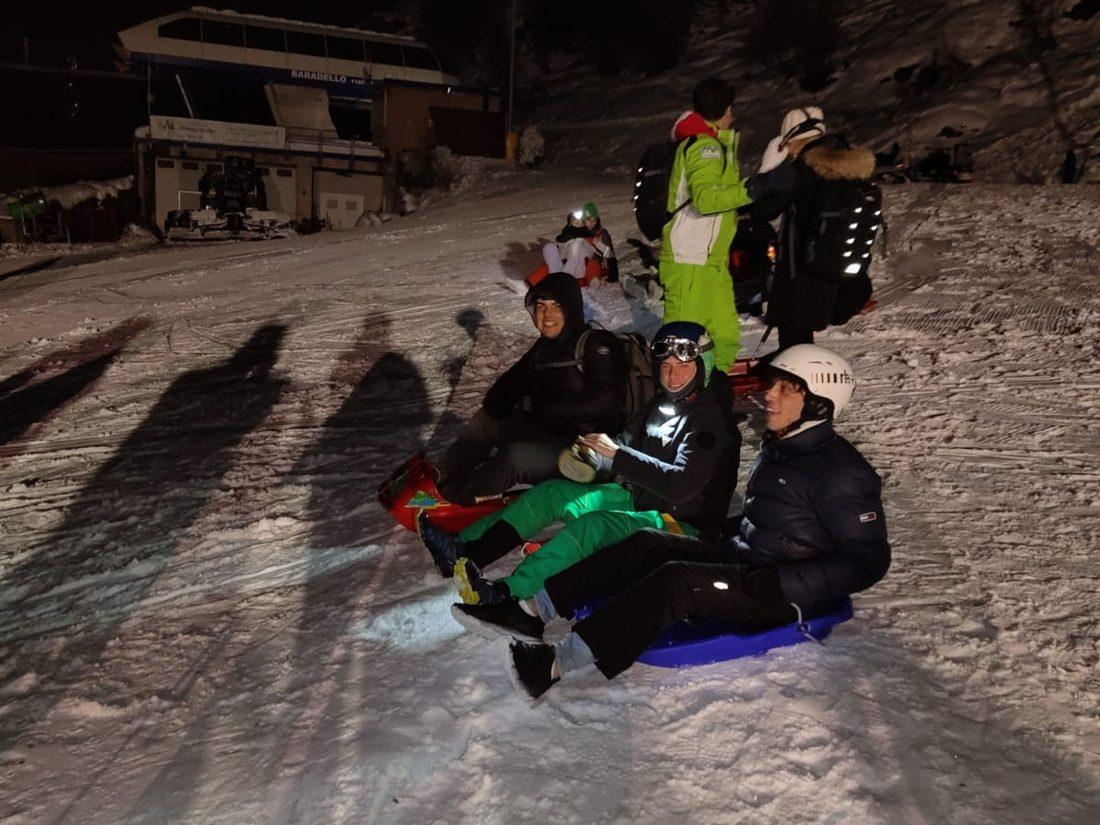 Bob e slittini fermi sulla neve davanti alla stazione della seggiovia, di notte